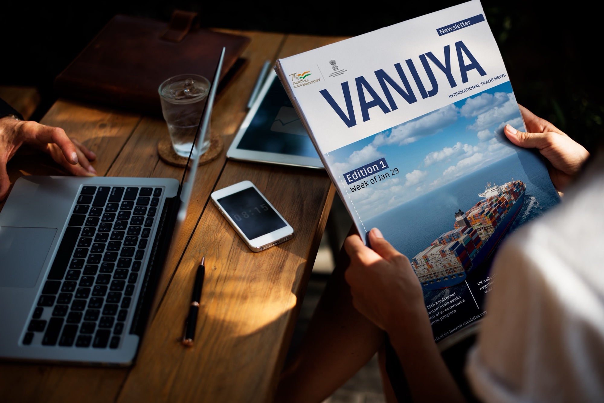 Reading the VANIJYA newsletter at a desk